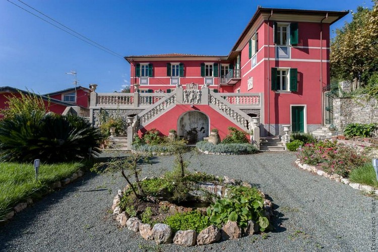 La facciata rosso ligure di Villa La Contessa con la scalinata barocca